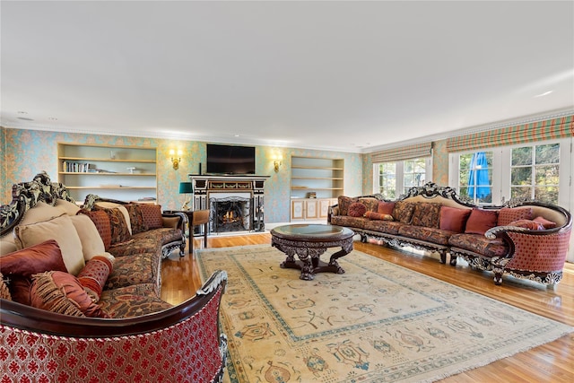 living room with crown molding, hardwood / wood-style floors, and built in features