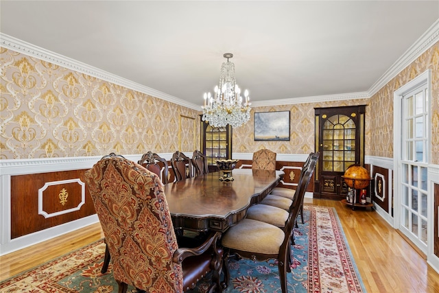 dining area featuring crown molding, an inviting chandelier, and light hardwood / wood-style floors