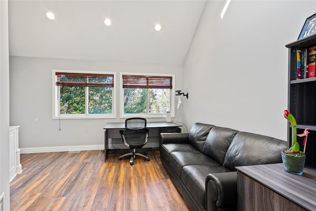 office featuring lofted ceiling and light hardwood / wood-style floors