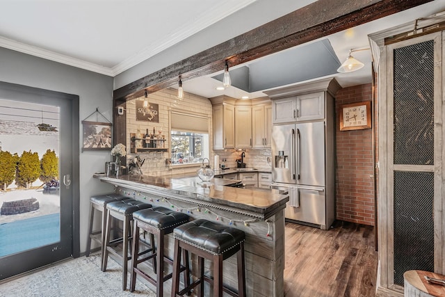 kitchen with high end refrigerator, a kitchen bar, and kitchen peninsula