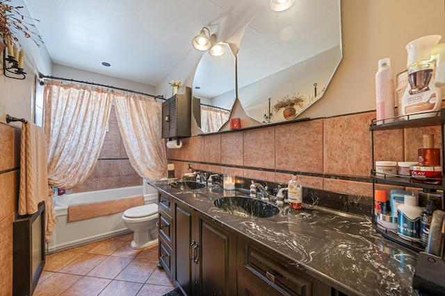 full bathroom with shower / bath combo, tile walls, vanity, tile patterned floors, and toilet