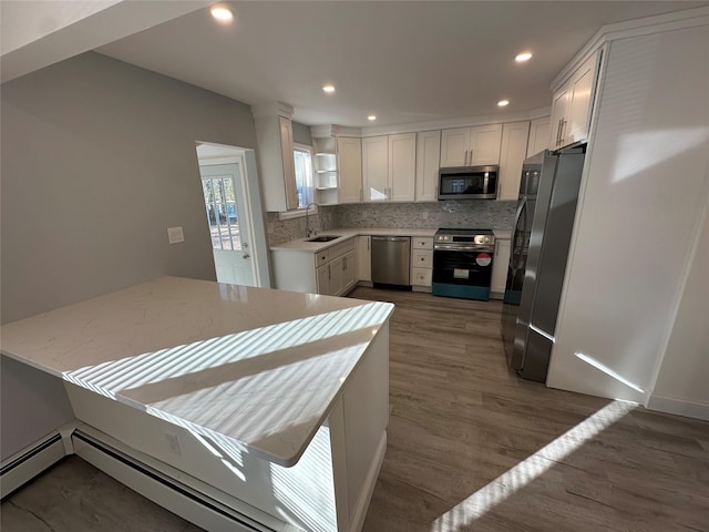 kitchen with dark hardwood / wood-style floors, sink, white cabinets, stainless steel appliances, and light stone countertops