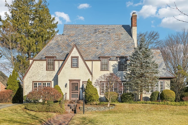 tudor-style house with a front yard