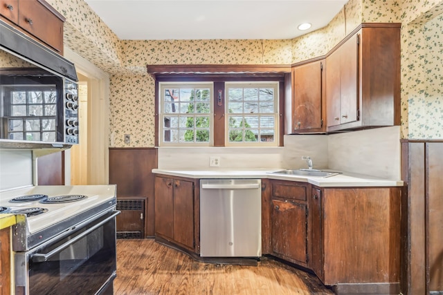 kitchen with range with electric stovetop, sink, stainless steel dishwasher, and light hardwood / wood-style floors