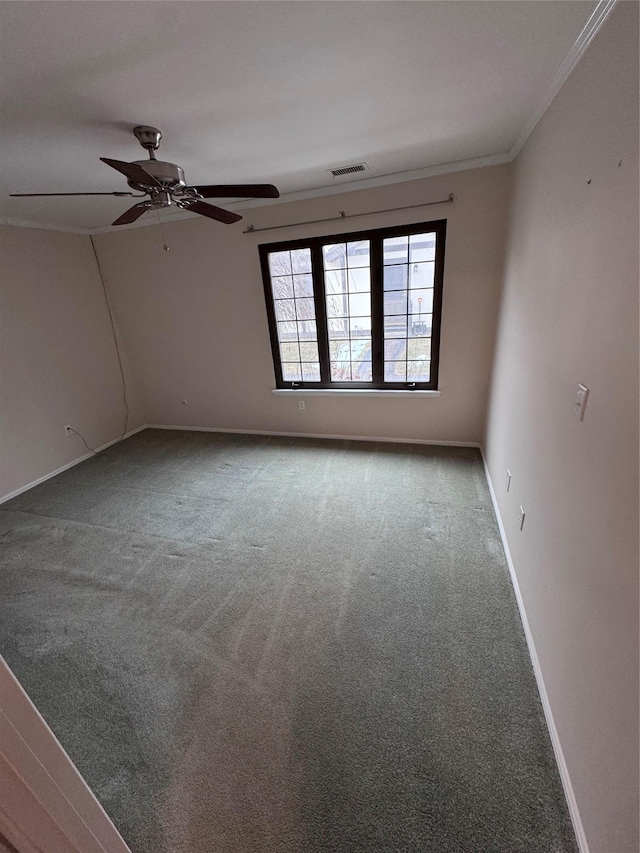 empty room with crown molding, ceiling fan, and carpet flooring