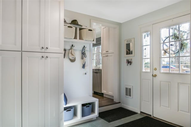 mudroom featuring a healthy amount of sunlight and dark tile patterned flooring