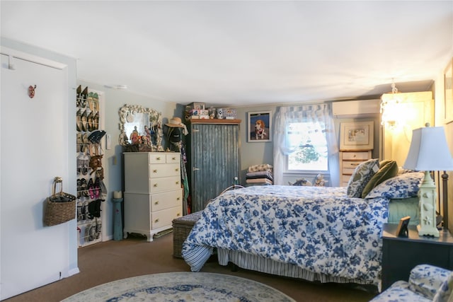 bedroom featuring a wall unit AC and dark carpet