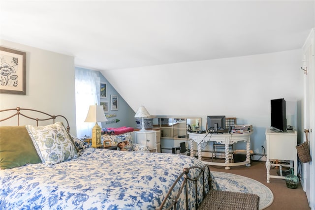 carpeted bedroom featuring vaulted ceiling and a baseboard heating unit