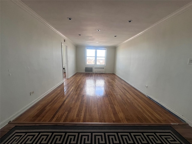 empty room featuring radiator, crown molding, and wood-type flooring