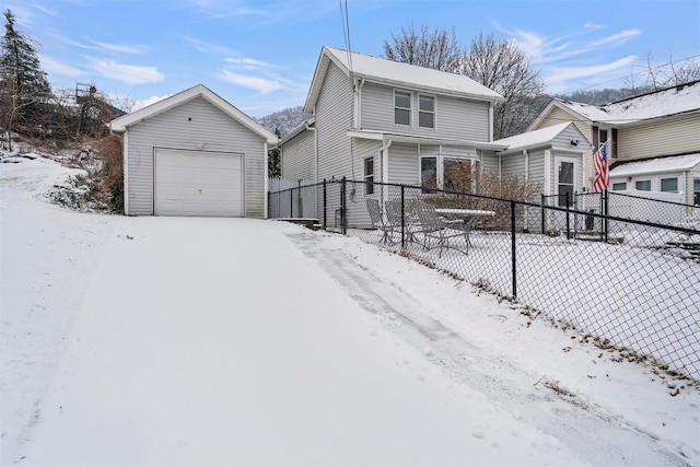 front facade featuring a garage and an outbuilding