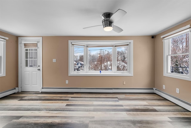 unfurnished dining area with ceiling fan, a baseboard heating unit, and light hardwood / wood-style floors