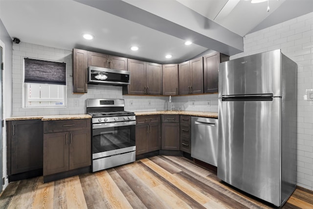 kitchen featuring dark brown cabinetry, stainless steel appliances, sink, and light hardwood / wood-style floors