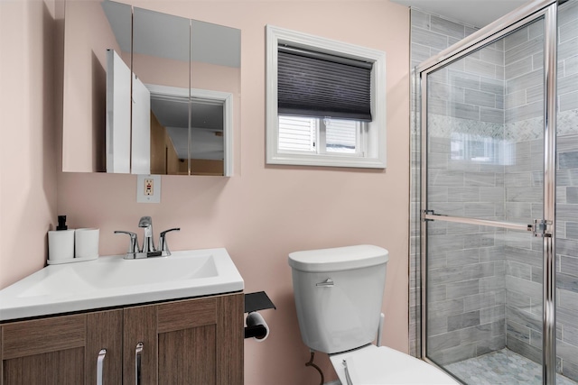 bathroom with walk in shower, vanity, and toilet