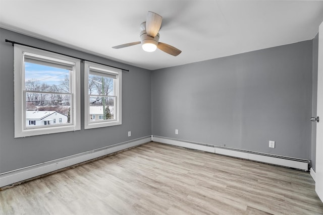 unfurnished room with ceiling fan, light hardwood / wood-style floors, and a baseboard heating unit