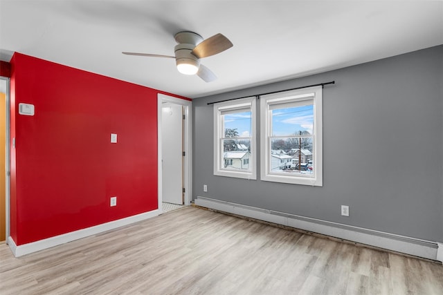 unfurnished bedroom featuring ceiling fan, light wood-type flooring, and a baseboard heating unit