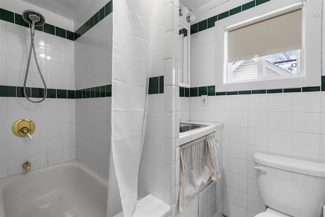 bathroom featuring tile walls, shower / bath combination with curtain, and toilet