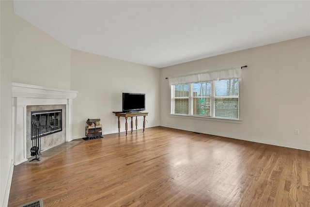 unfurnished living room with hardwood / wood-style flooring and a premium fireplace