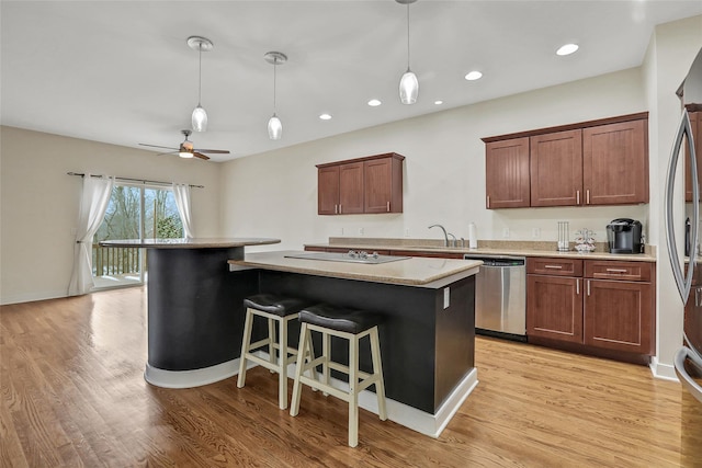 kitchen featuring pendant lighting, a breakfast bar area, stainless steel dishwasher, and a kitchen island