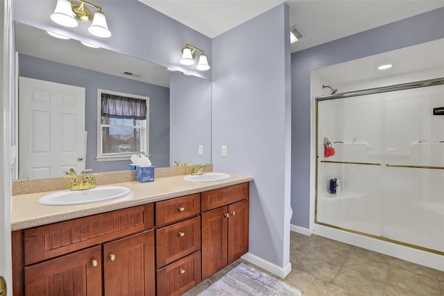 bathroom featuring a shower with door, vanity, and tile patterned floors