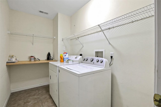 clothes washing area with washer and dryer and light tile patterned floors