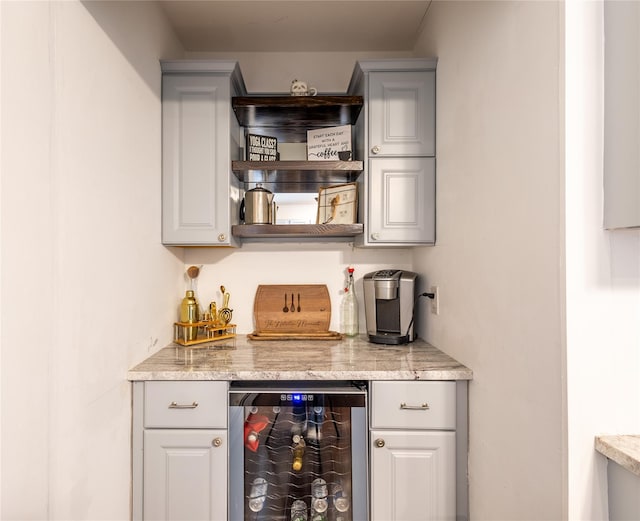 bar with wine cooler and light stone counters