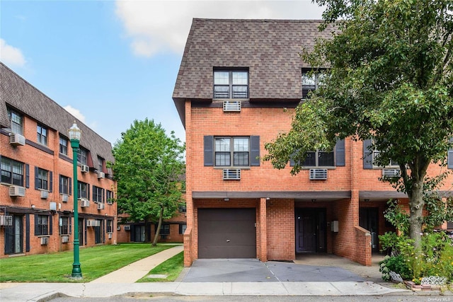 multi unit property featuring a garage and a front lawn