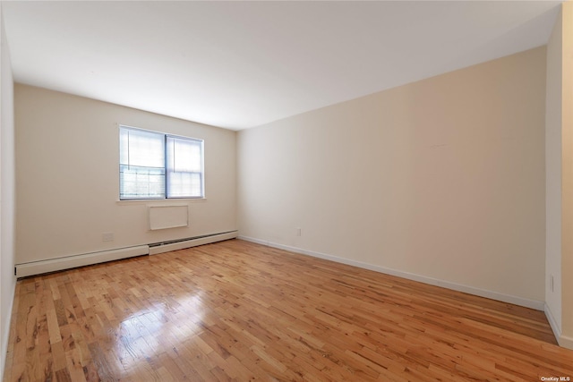 empty room with a baseboard radiator and light wood-type flooring