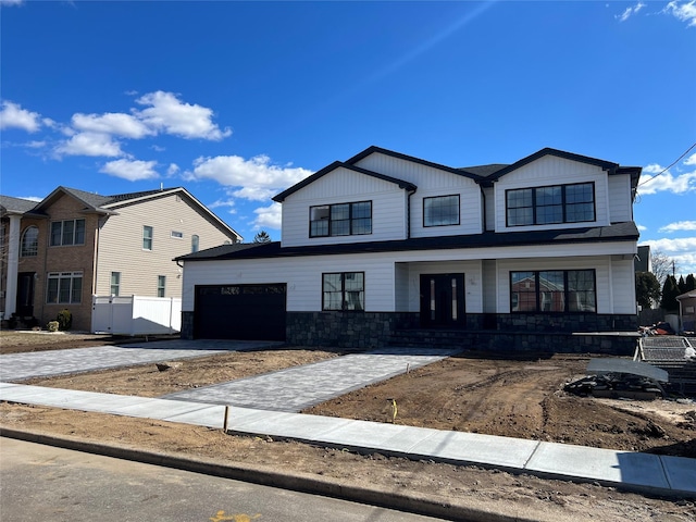 view of front of home featuring a porch, stone siding, decorative driveway, and an attached garage