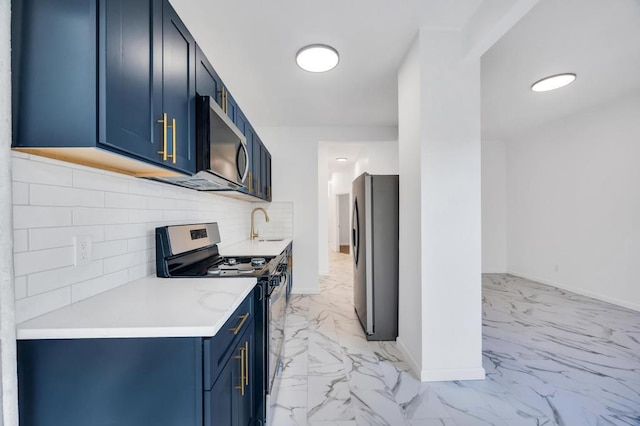 kitchen with stainless steel appliances, tasteful backsplash, sink, and blue cabinets