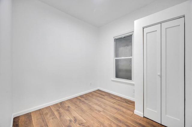 unfurnished bedroom featuring a closet and light wood-type flooring