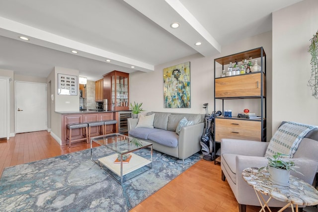 living room with beamed ceiling, wine cooler, and light hardwood / wood-style floors