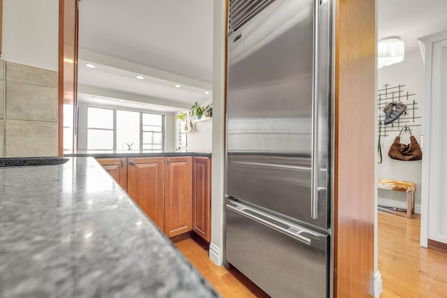 kitchen featuring built in refrigerator and light hardwood / wood-style flooring