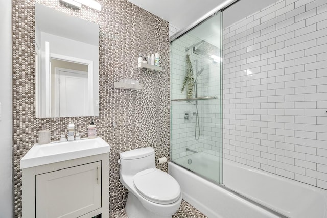 full bathroom featuring vanity, shower / bath combination with glass door, and toilet