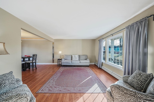 living room featuring wood-type flooring and a baseboard heating unit