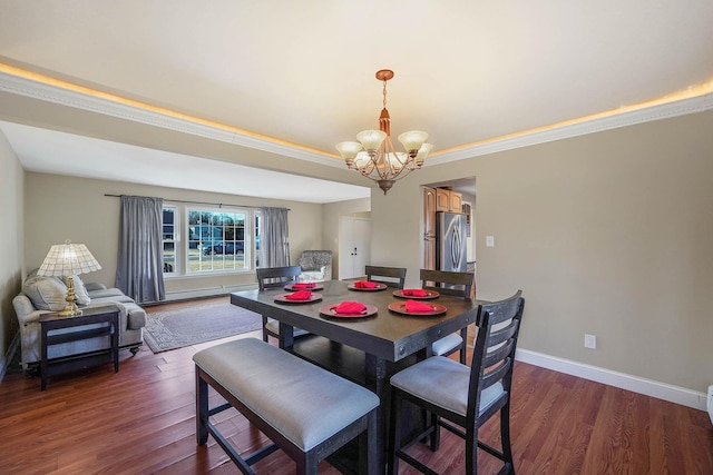 dining area with an inviting chandelier, ornamental molding, and dark wood-type flooring