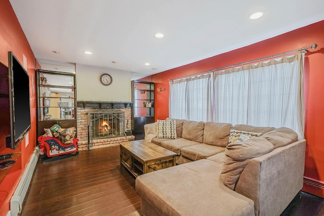 living room featuring a baseboard heating unit, hardwood / wood-style flooring, and a fireplace