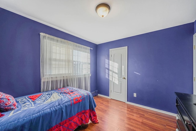 bedroom featuring wood-type flooring and baseboard heating