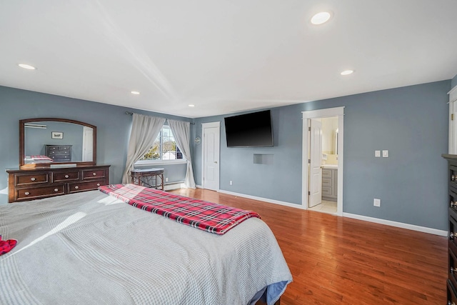 bedroom featuring ensuite bath, a closet, and light wood-type flooring