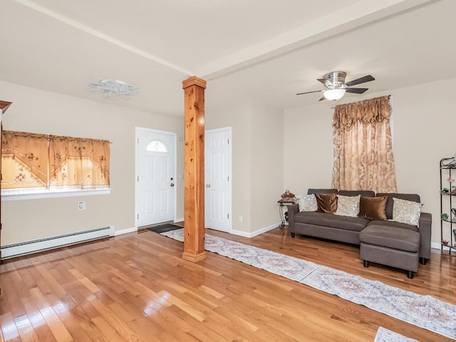 living room featuring baseboard heating, ceiling fan, decorative columns, and hardwood / wood-style floors