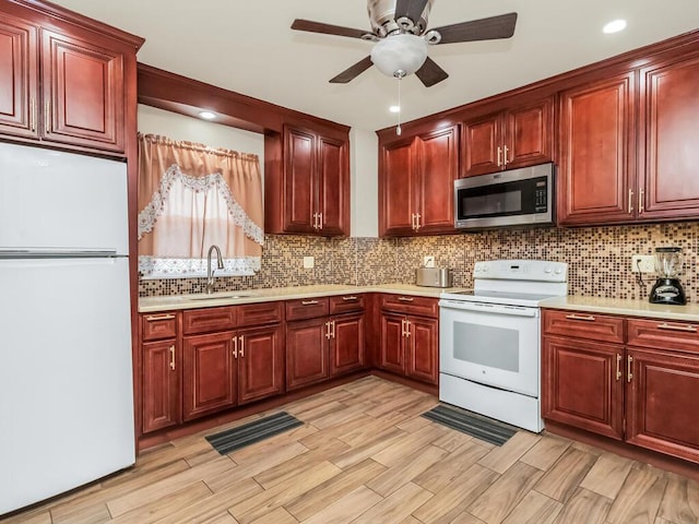 kitchen featuring sink, white appliances, ceiling fan, and backsplash