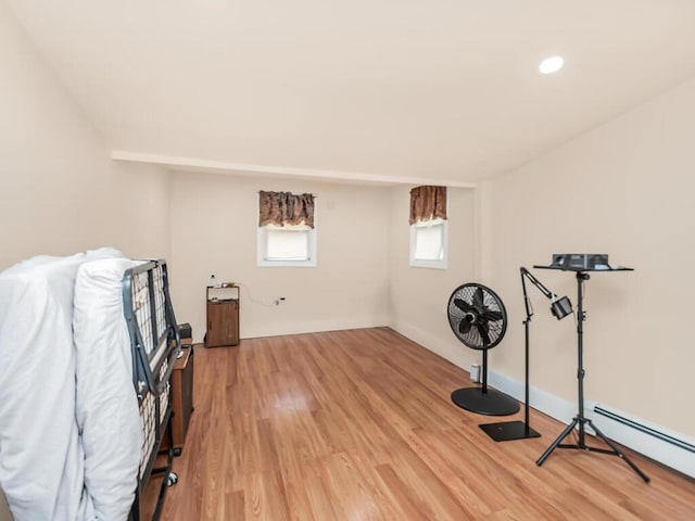 workout room featuring a baseboard heating unit and light hardwood / wood-style floors