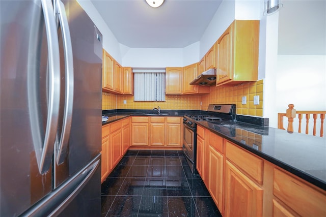 kitchen with stainless steel appliances, sink, decorative backsplash, and dark stone countertops