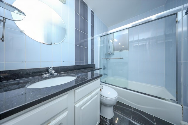 full bathroom featuring tile walls, tile patterned flooring, enclosed tub / shower combo, vanity, and toilet