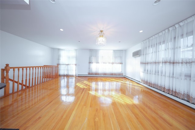 empty room featuring a wall mounted air conditioner and hardwood / wood-style flooring