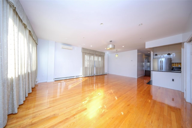 unfurnished living room with light hardwood / wood-style flooring, an AC wall unit, and baseboard heating