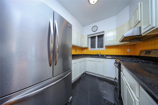 kitchen with sink, dark tile patterned floors, appliances with stainless steel finishes, white cabinets, and decorative backsplash