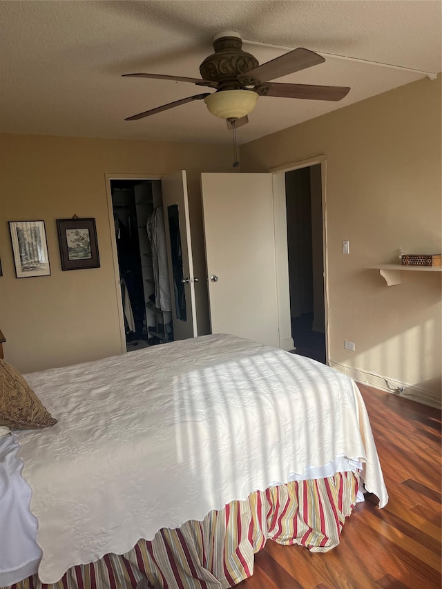 bedroom with ceiling fan, hardwood / wood-style floors, and a textured ceiling