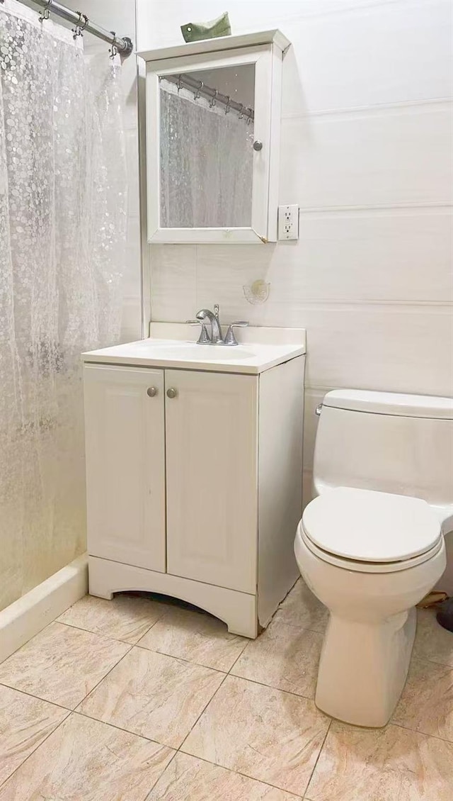 bathroom featuring vanity, a shower with shower curtain, and toilet