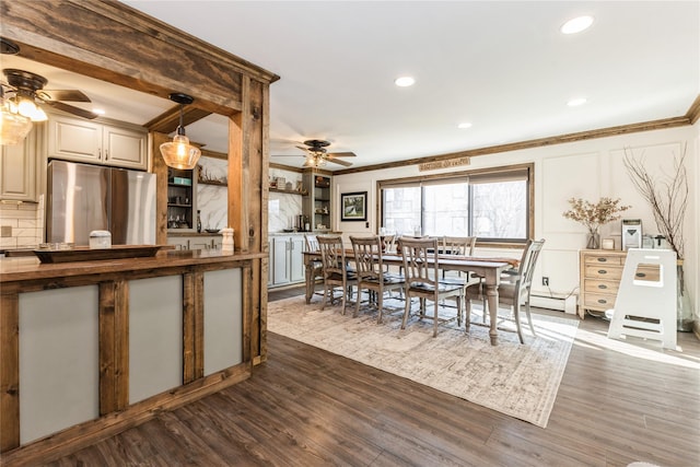 dining space with ornamental molding, dark wood-type flooring, and ceiling fan