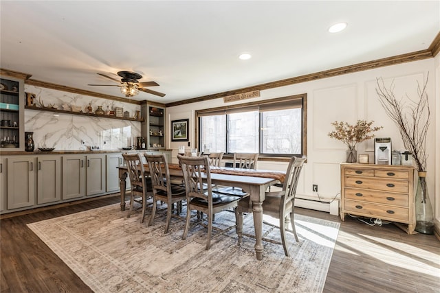 dining room with crown molding, ceiling fan, dark wood-type flooring, and a baseboard heating unit